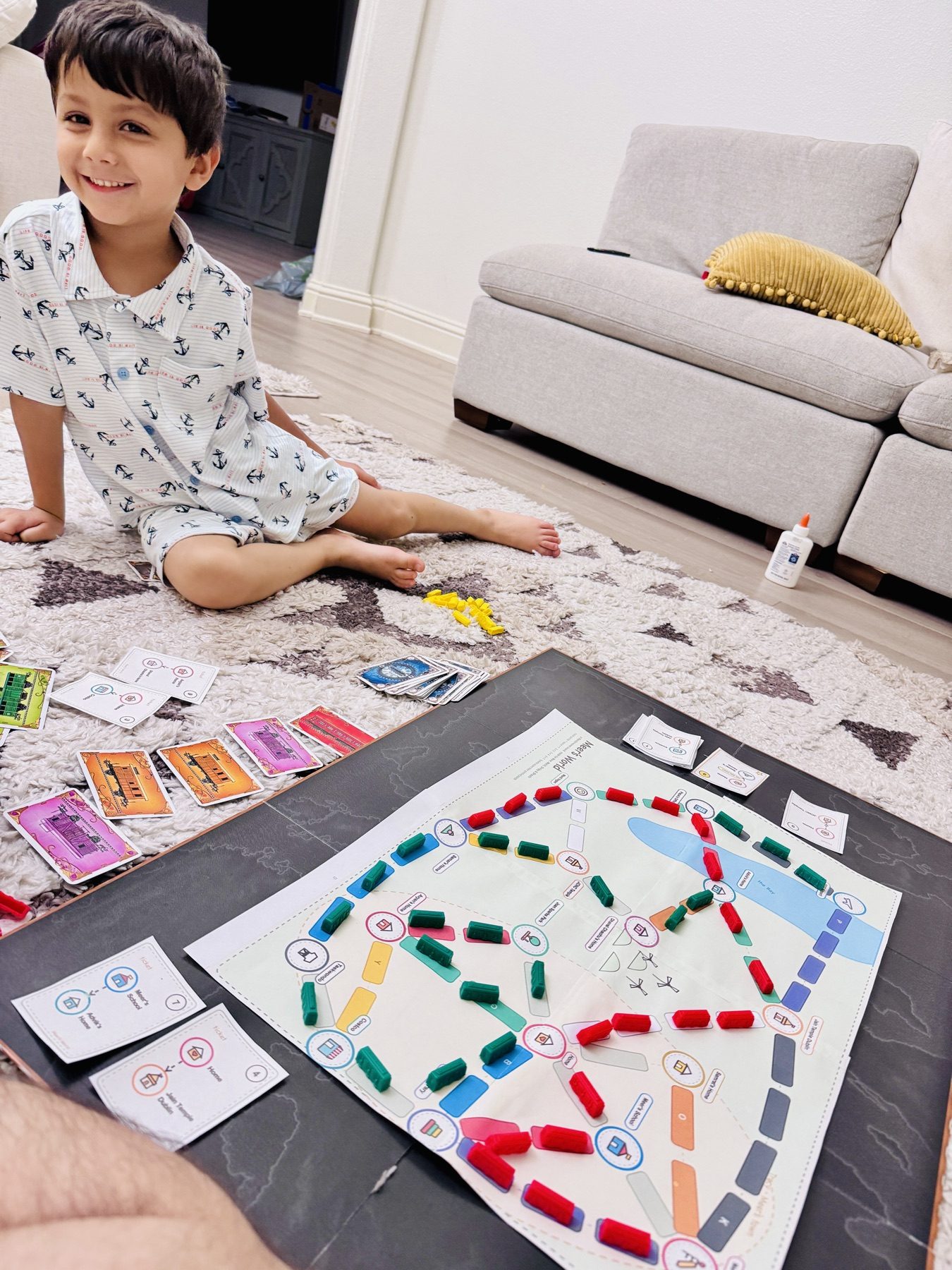 Meer smiling beside a Mapventure board covered with colorful route pieces.